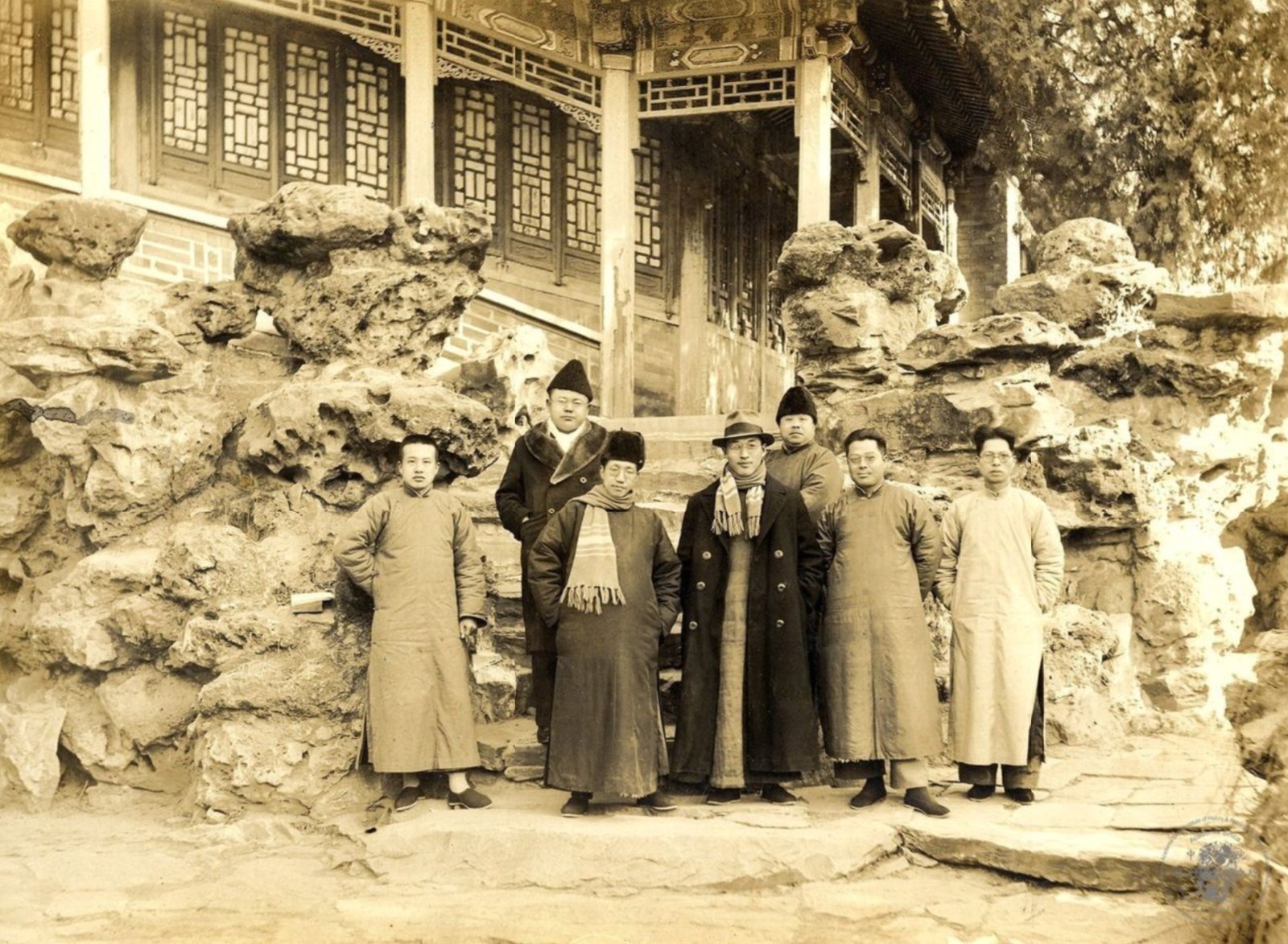 1936 年 1 月 28 日，史語所同仁七人身著長袍、大衣，於北平北海靜心齋殿宇前的太湖石假山旁合影，含傅斯年、陳寅恪、梁思永、徐中舒